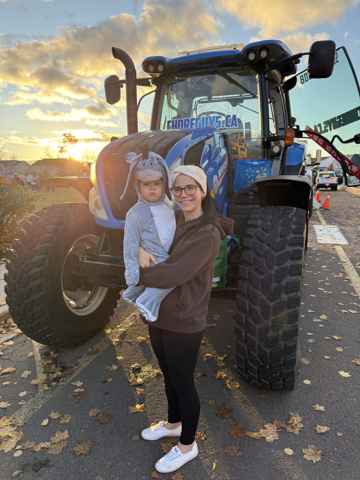 A young trick-or-treater in costume in front of a Choreguys tractor at a school trunk-or-treat